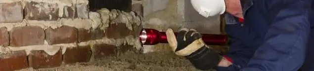 Pest control technician inspecting a crawl space for ant activity and entry points in Wichita, KS